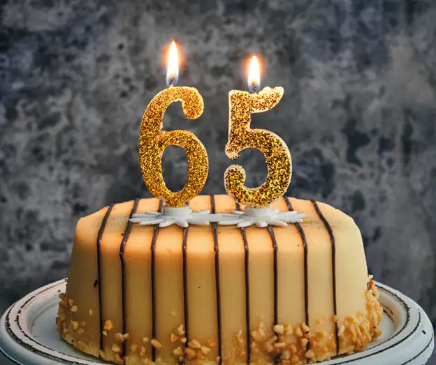 This is a photo of a birthday cake with candles that make the number 65.